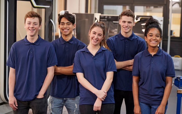 Es sind fünf fröhliche junge Personen in blauen Hemden zu sehen.